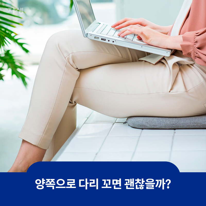 다리를 꼬고 앉아 노트북을 사용하고 있는 모습